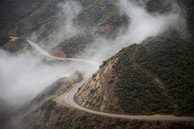 A winding mountain road emerging through fog
